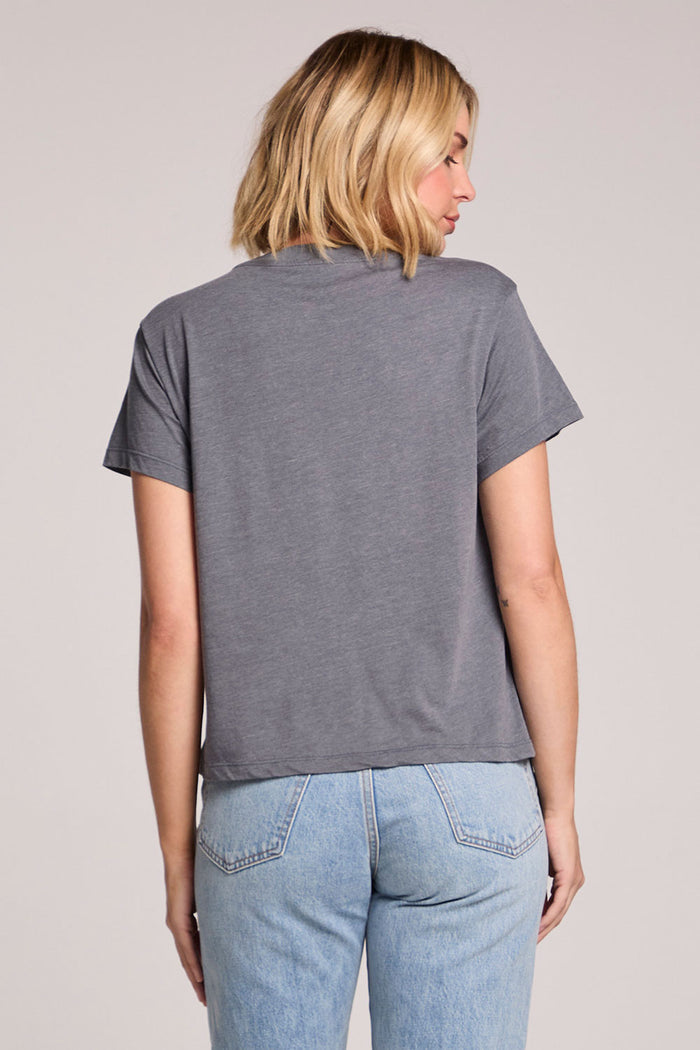 Back view of a woman wearing the Chaser David Bowie Live in Japan Tee on a neutral background