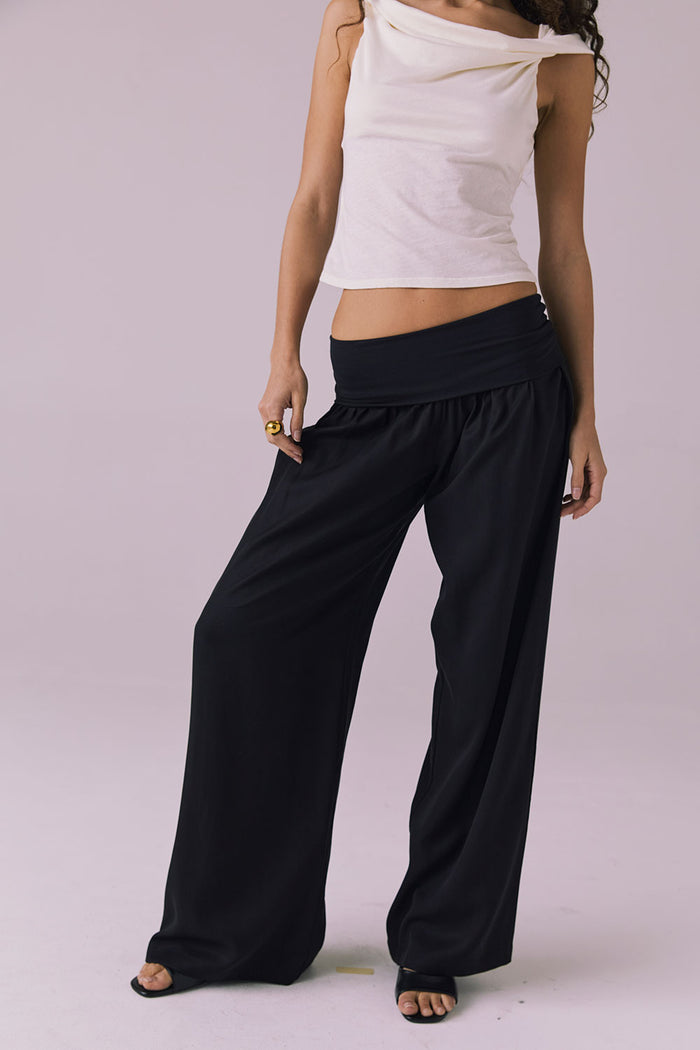 Model wearing the Chaser Didion Licorice Black Trousers styled with the Roxanne Starry White Tank and black heeled sandals