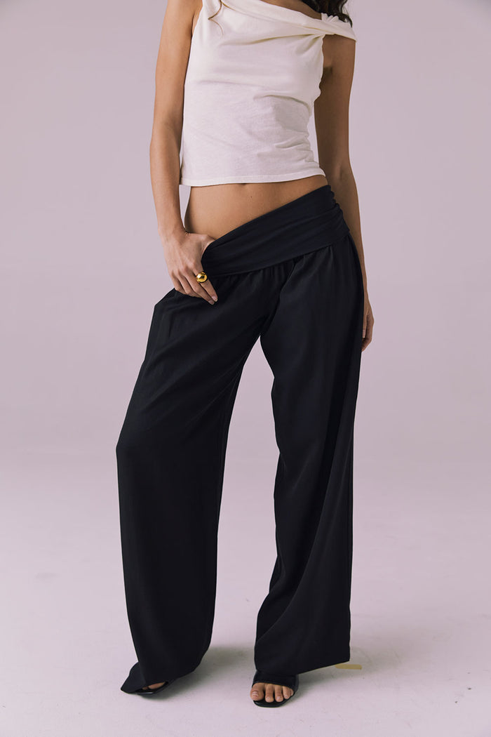 Model wearing the Chaser Didion Licorice Black Trousers styled with the Roxanne Starry White Tank and black heeled sandals