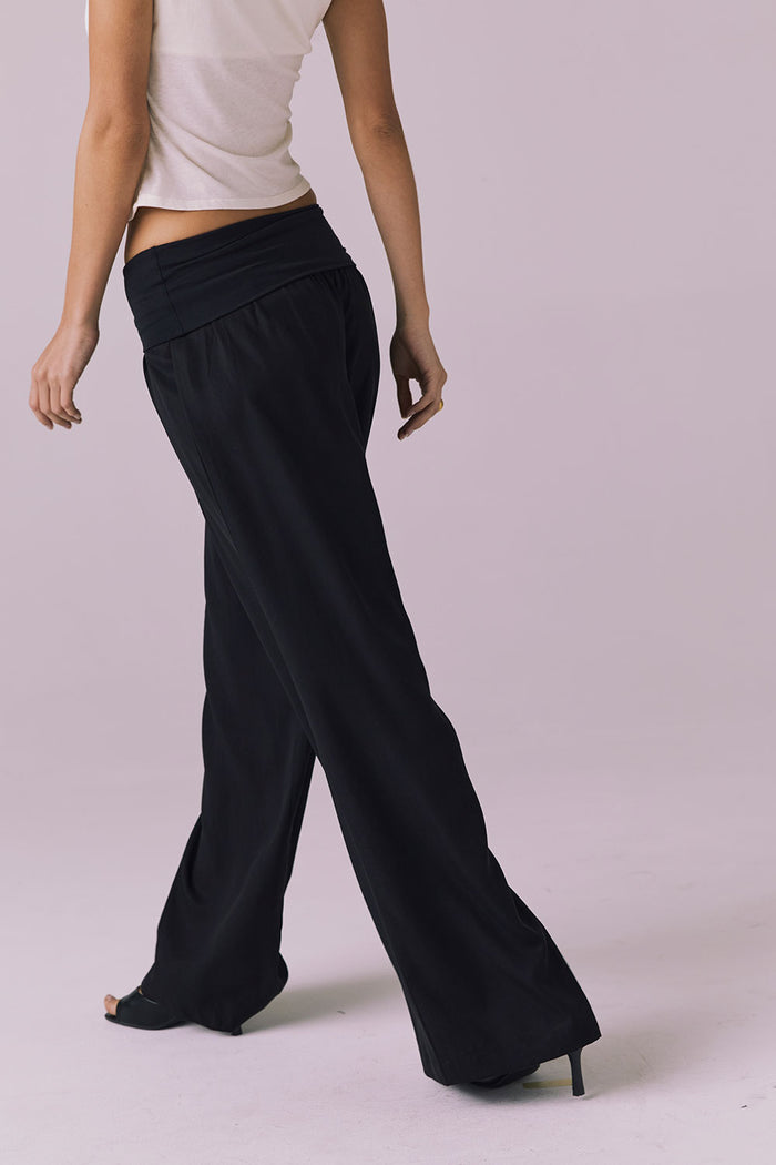 Model turned slightly back wearing the Chaser Didion Licorice Black Trousers emphasizing the easy lounge silhouette