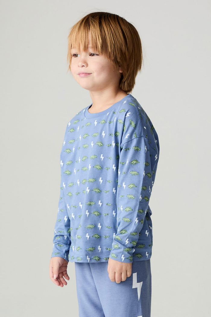 Side angle view of a boy wearing the Chaser Dino Bolts Boys Tee on a neutral background with blue pants