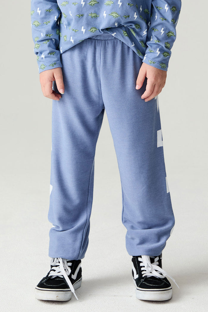 Front  view of a boy wearing the Chaser Dino Bolts Pants Boys Jogger on a neutral background with blue shirt