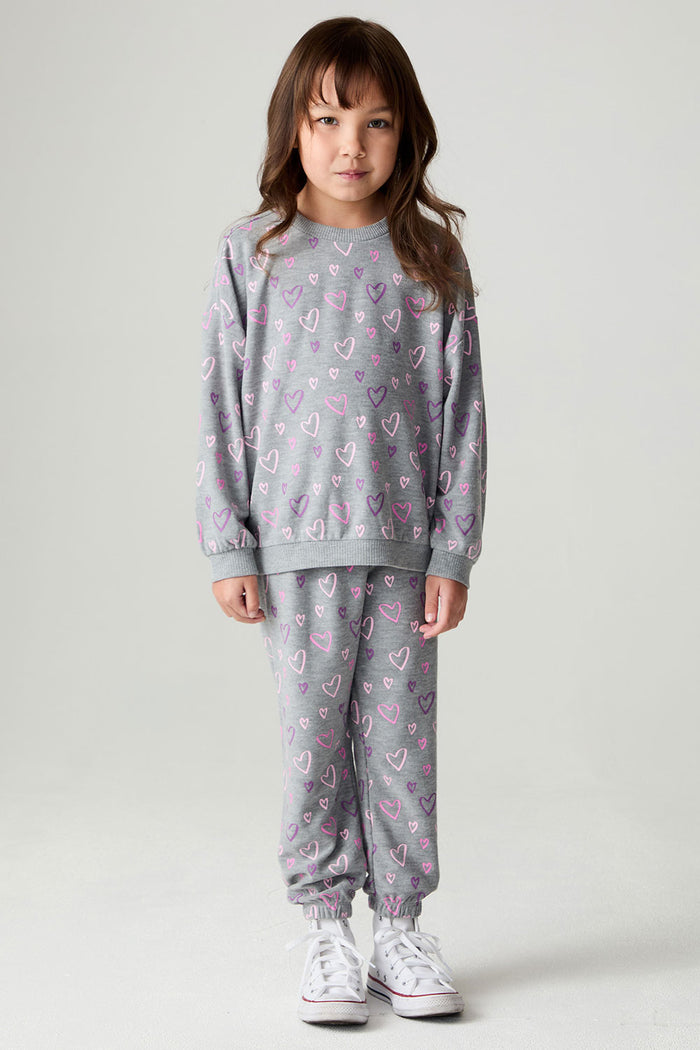 A full body front view of a girl wearing the Chaser Ditsy Hearts Girls Tee on a neutral background