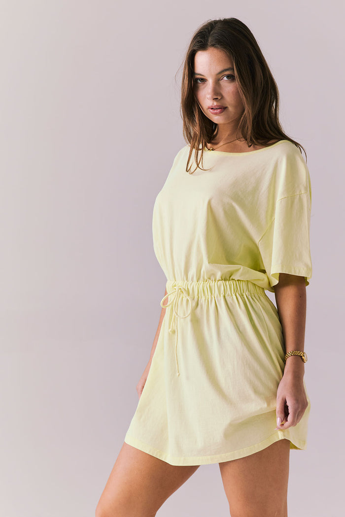 Model wearing the Chaser Dixie Panna Cotta Mini Dress with a soft yellow-cream hue and effortless tee silhouette