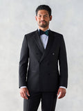 Man in a black double-breasted tuxedo jacket with peak lapels and a patterned bow tie.