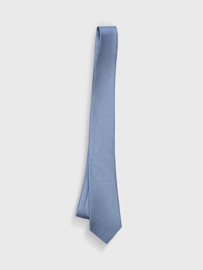 Dusty blue silk necktie with a twill weave, hanging against a white background.