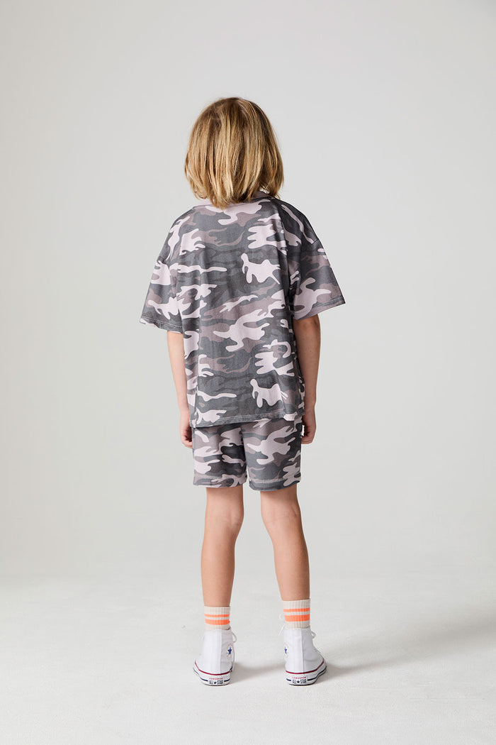 Full body back view of a boy wearing the Chaser Dusty Camo Tee  on a neutral background