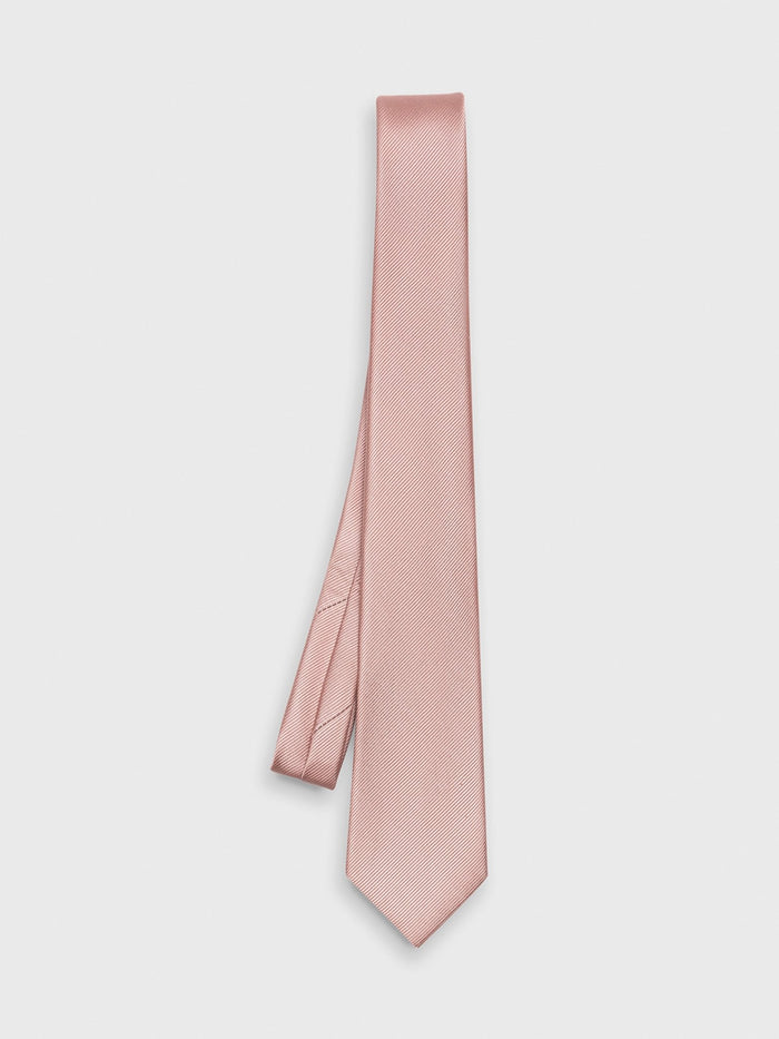 Dusty rose silk necktie laid flat in a loose fold on a grey background.