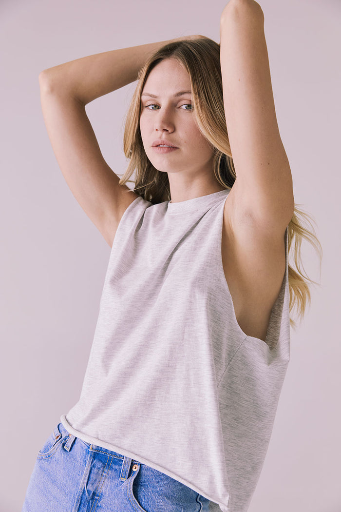 Front view of the Chaser Eagle Light Heather Grey Tank paired with blue denim, showing the clean crew neckline and easy fit