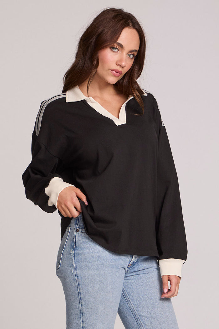 Front view of a woman wearing the Chaser Eddith Black and Heather Grey Collar Sweatshirt on a neutral background with bluejeans