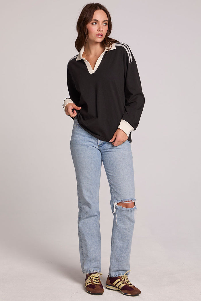 A full body front view of a woman wearing the Chaser Eddith Black and Heather Grey Collar Sweatshirt on a neutral background