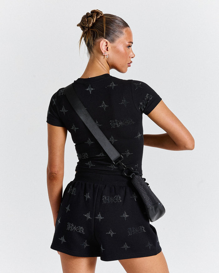 Woman wearing a black outfit with star patterns against a white background
