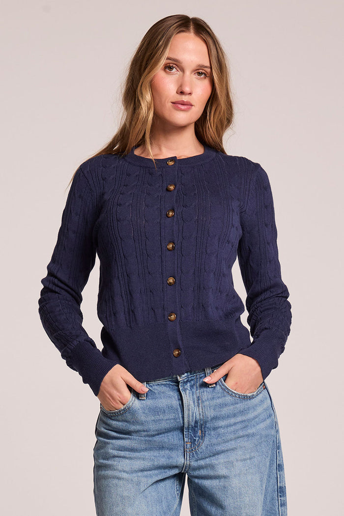Front view of a woman wearing the Chaser  Eliza Admiral Cardigan and jeans on a neutral background