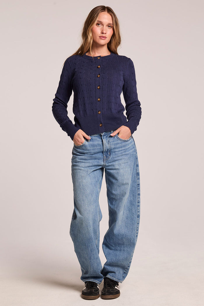 Front view of a woman wearing the Chaser  Eliza Admiral Cardigan and shoes on a neutral background