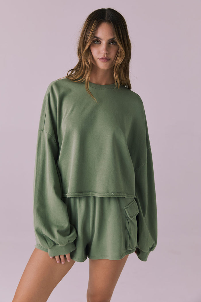 Front-facing studio image of the Chaser Eliza Meadow Green Crop Pullover paired with matching Rileyy Shorts showing the relaxed fit and raw-edge cropped hem