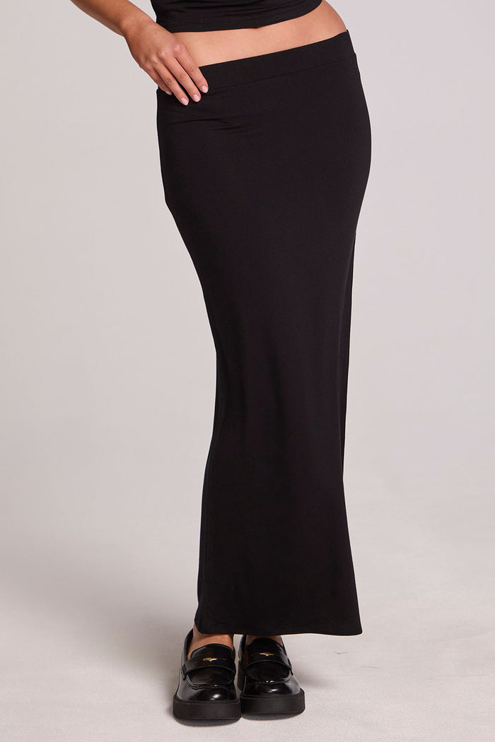 Front view of a woman wearing the Chaser  Eloyse Black Maxi Skirt and black top on a neutral background