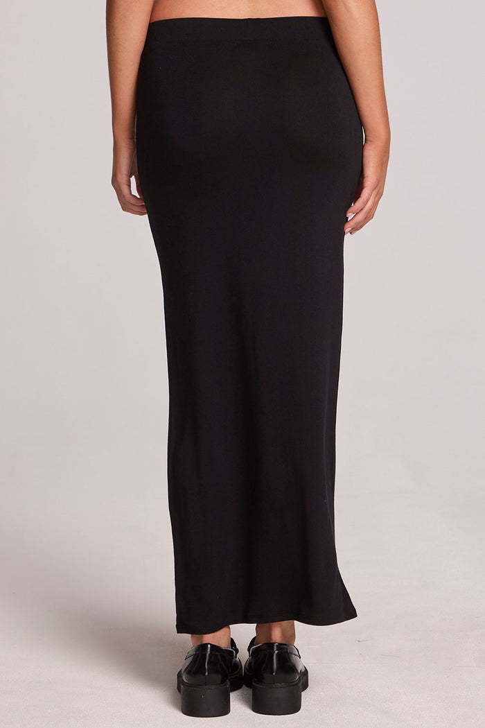 Back view of a woman wearing the Chaser  Eloyse Black Maxi Skirt on a neutral background