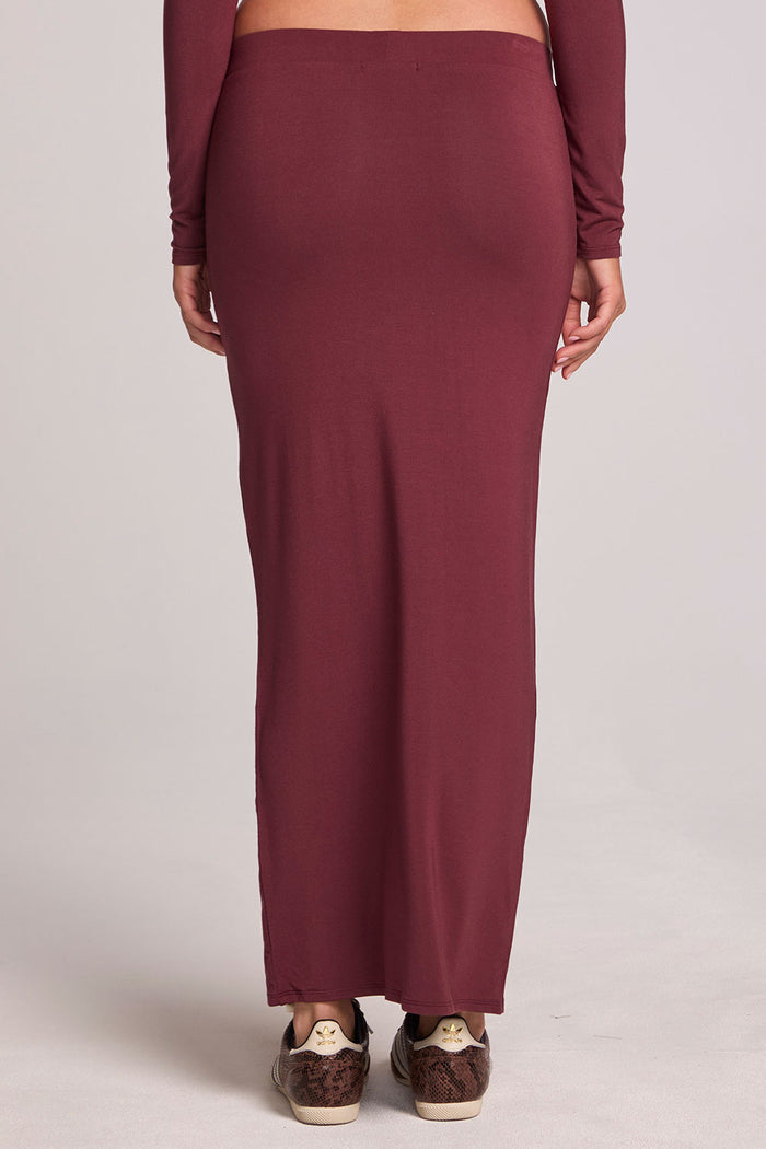 Back view of a woman wearing the Chaser Eloyse Brick Red Skirt on a neutral background with red top