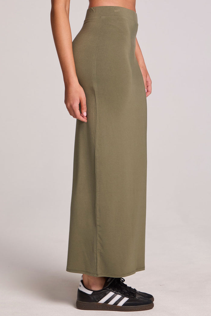 Side view of a woman wearing the Chaser Eloyse Forager Green Skirt on a neutral background with arms at sides
