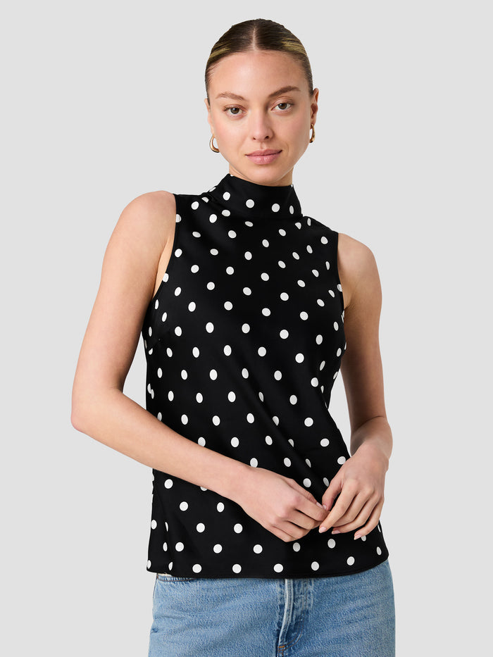 A woman wearing a eco blend satin black and white Top with a polka dot pattern, a high neckline, an invisible back zip fastening and a sleeveless regular fit.