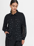 A woman wearing a black Shirt with long balloons sleeves, a pointed collar, a button through fastening, front metal stud embellishments and a relaxed fit.
