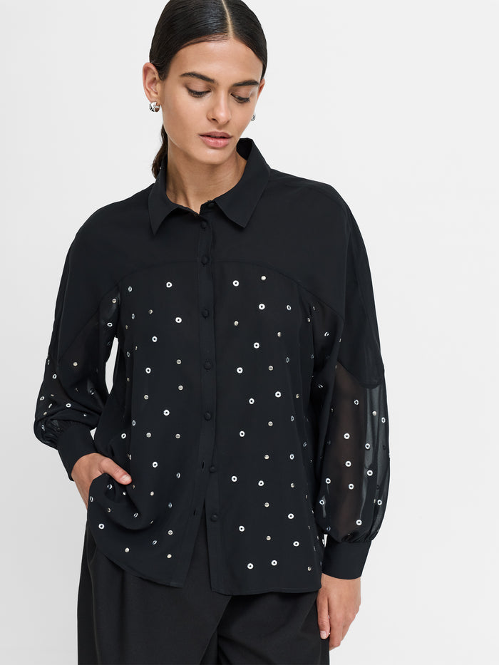A woman wearing a black Shirt with long balloons sleeves, a pointed collar, a button through fastening, front metal stud embellishments and a relaxed fit.