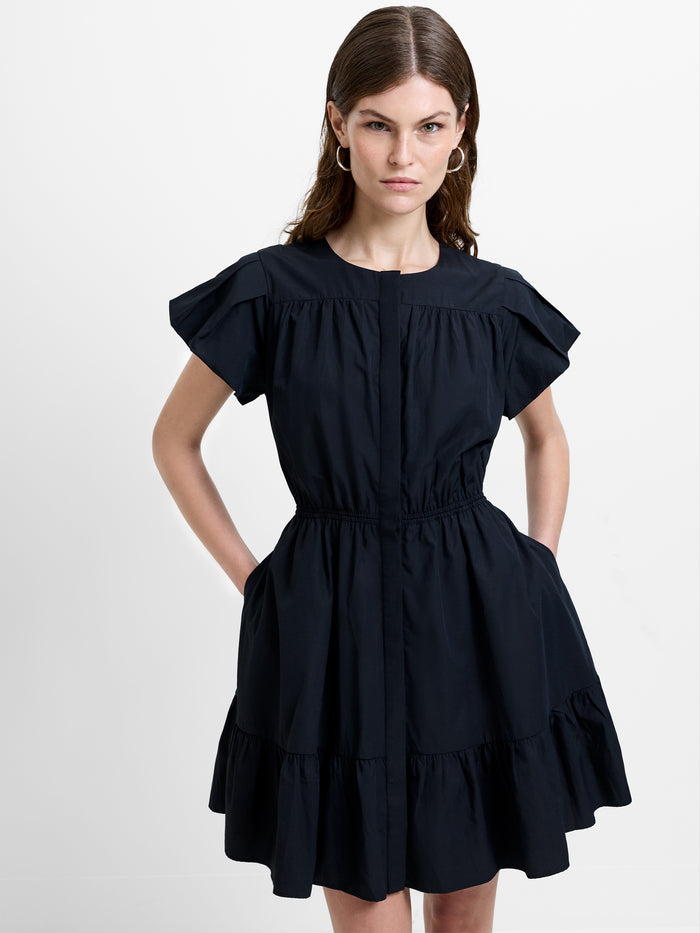 Woman wearing a poplin black mini dress, with flutter short sleeves, a crew neckline and a gathered waist
