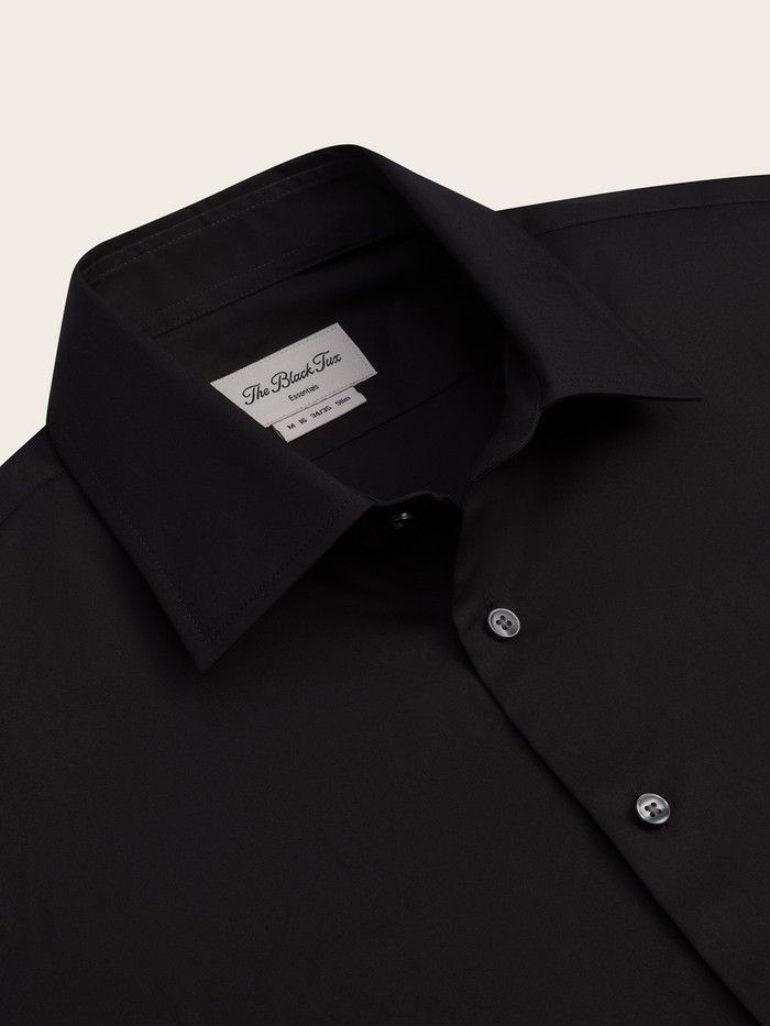 Close-up of black dress shirt collar and brand label.
