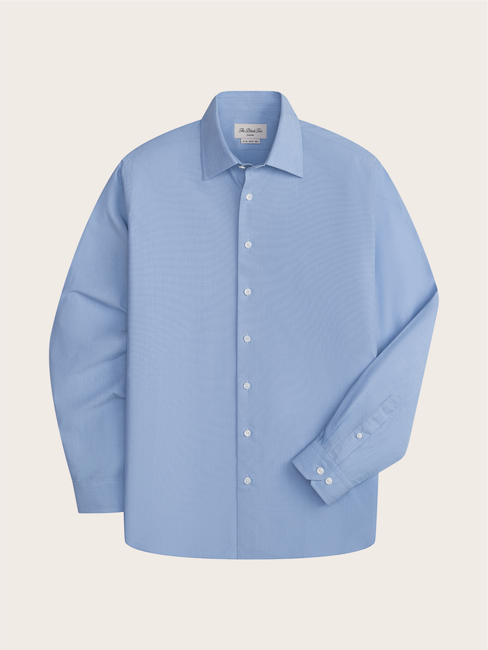 Light blue dress shirt laid flat, front view, showing spread collar and button placket.