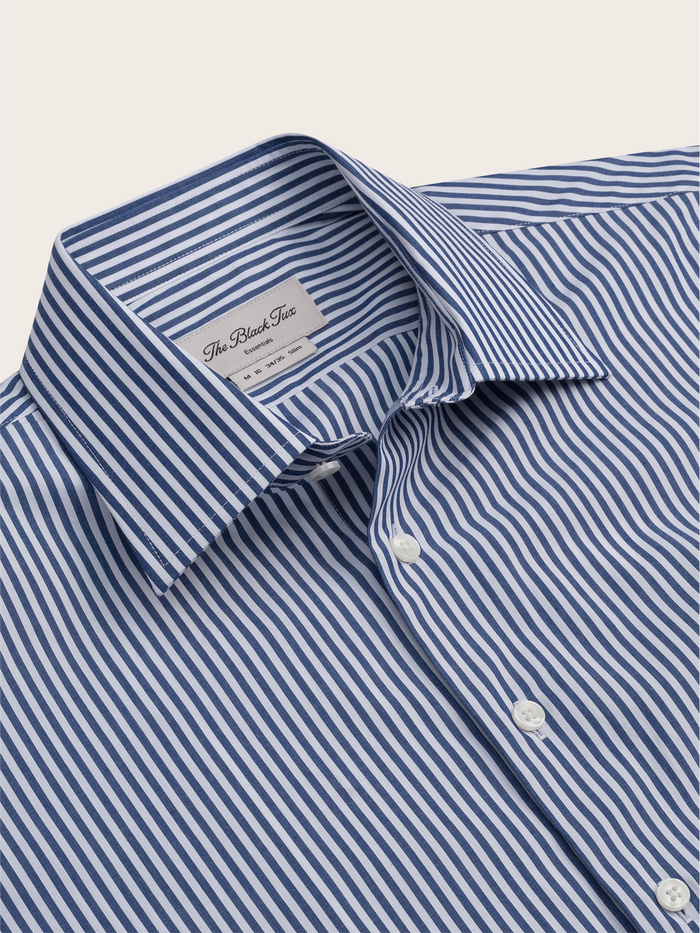 Close-up of navy striped dress shirt collar and brand label.