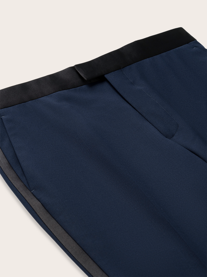 Close-up of navy tuxedo trouser satin side stripe and slanted pocket.