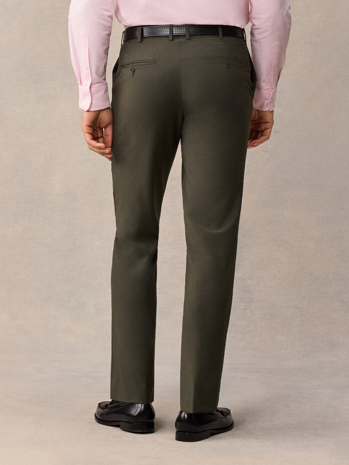 Back view of a man from waist down wearing olive suit trousers.