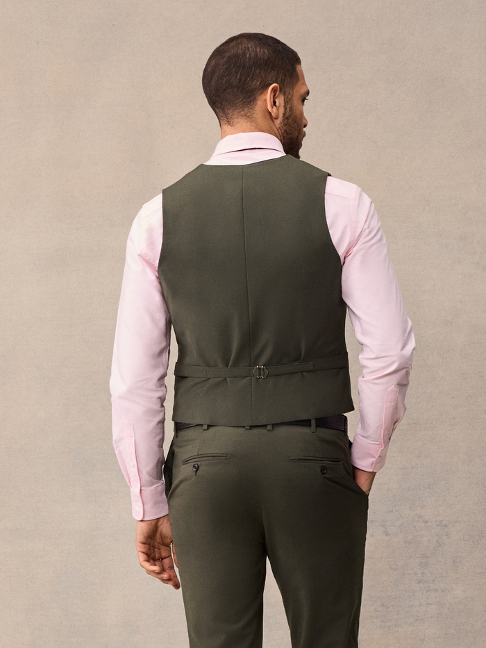 Back view of a man in an olive suit vest and matching trousers.