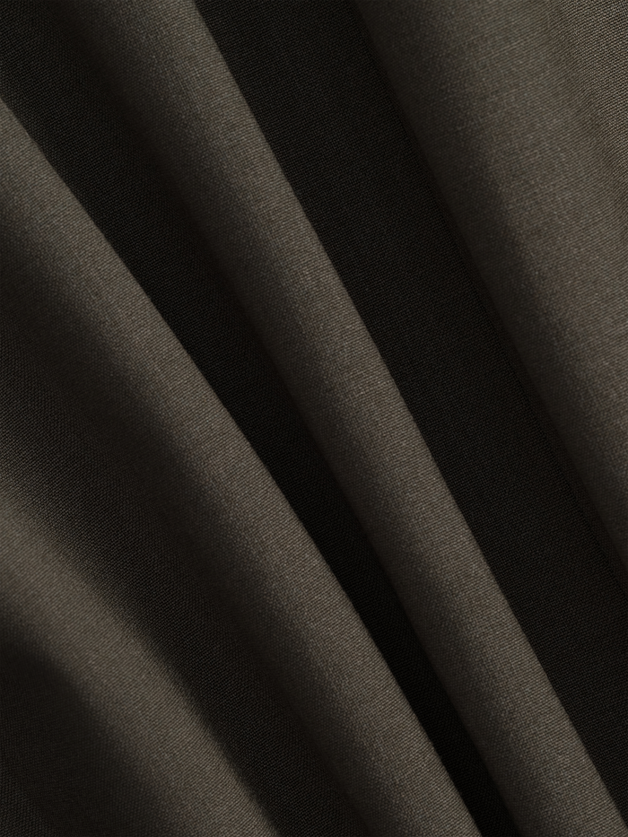 Close-up of olive suit fabric showing subtle texture and folds.