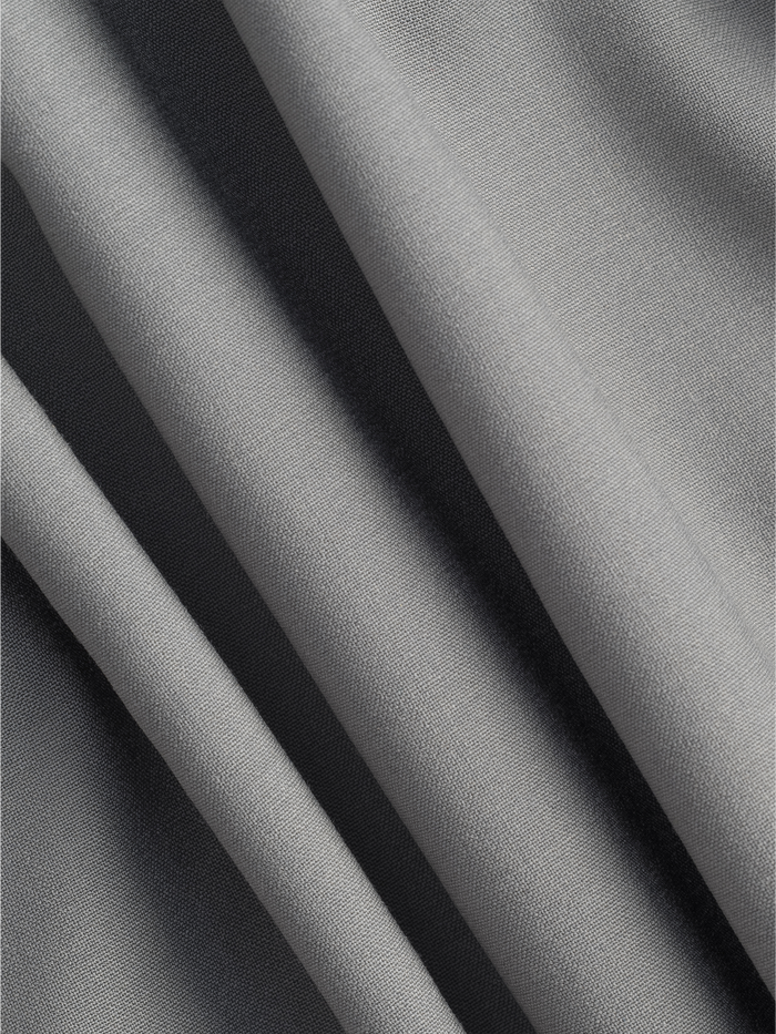 Close-up of folded sage suit fabric with a smooth texture.
