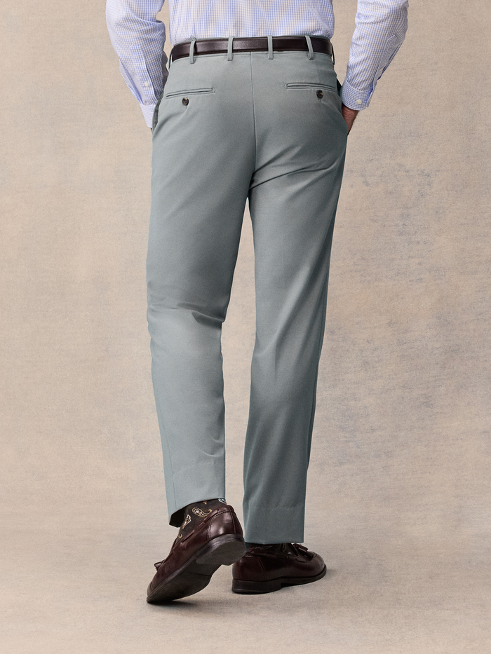Back view of a man from waist down wearing sage suit trousers.
