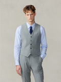 Man in a sage suit vest with a striped shirt and navy tie.