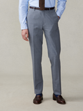 Man from waist down wearing slate grey trousers with a brown belt.