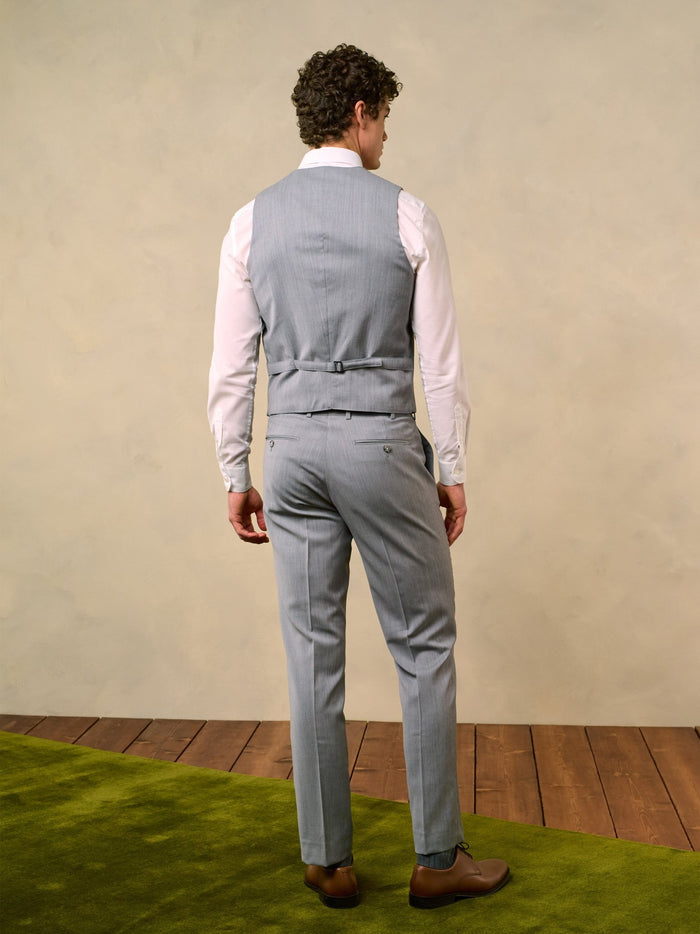 Back view of a man in a sterling grey suit vest and trousers.