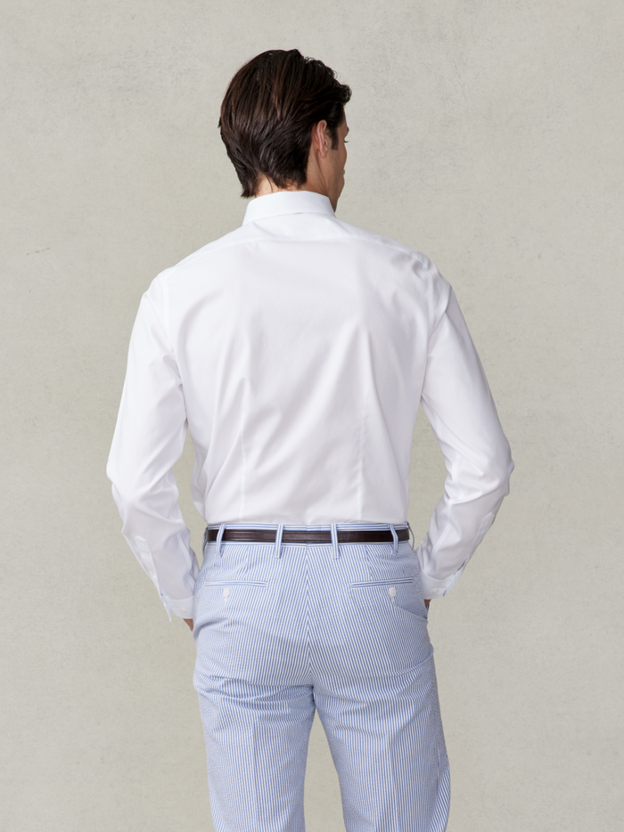 Back view of a man in a white dress shirt and striped trousers.