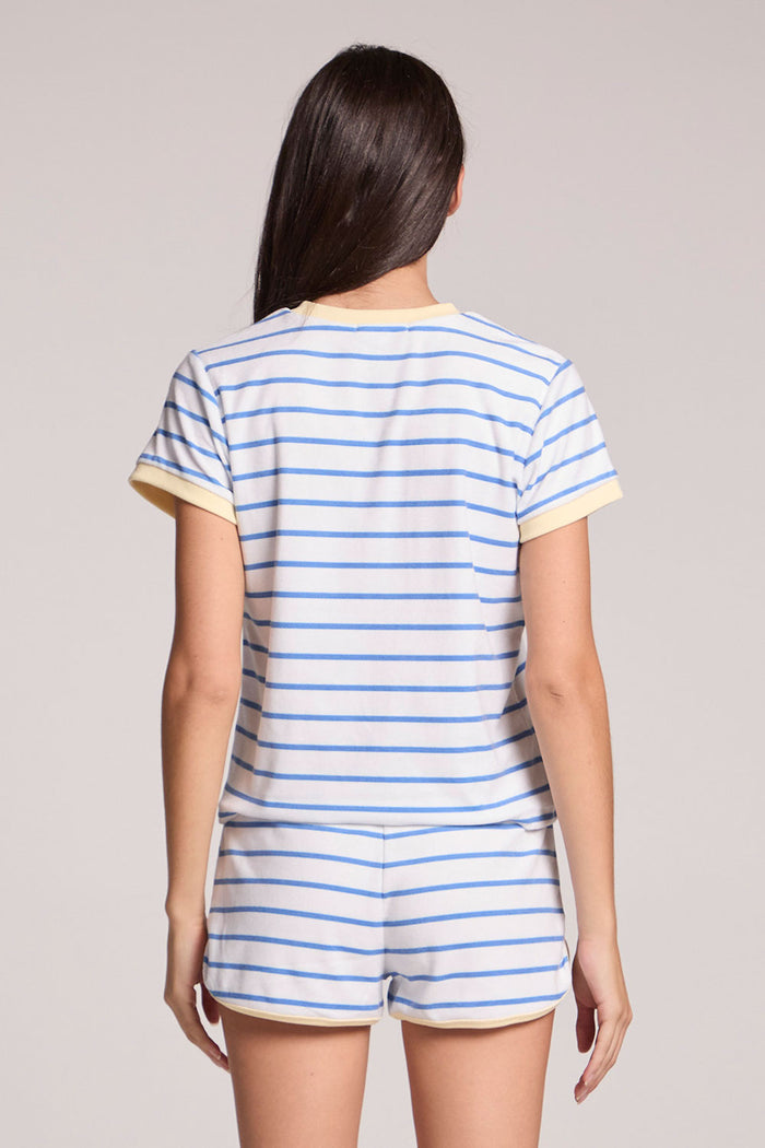 Back view of a woman wearing the Chaser  Evalina Blue Hydrangea Stripe Tee on a neutral background