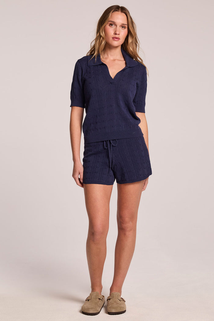 A full body front view of a woman wearing the Chaser Evie Admiral Shorts set on a neutral background