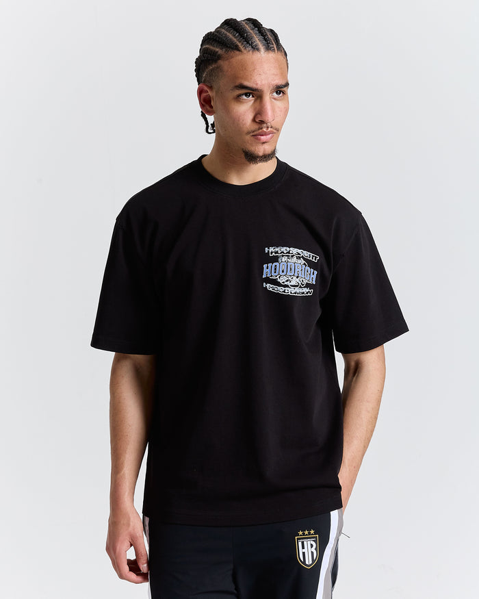 Person wearing a black t-shirt with a logo on a plain background