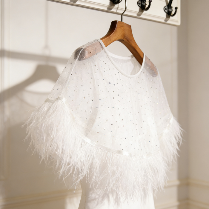 Feather bridal cape crafted from sheer chiffon with crystal embellishments and soft feather trim for wedding styling.