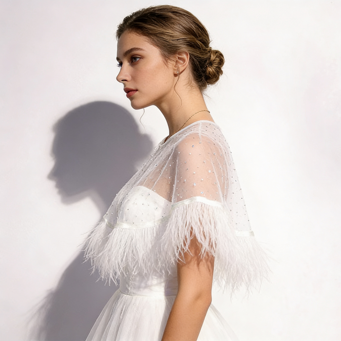 Feather bridal cape crafted from sheer chiffon with crystal embellishments and soft feather trim for wedding styling.