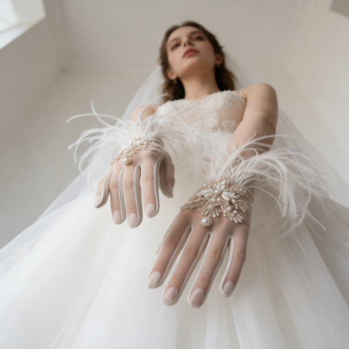 Bride wearing feather trimmed bridal gloves with pearl embroidery and a lace wedding gown during an elegant bridal photoshoot.
