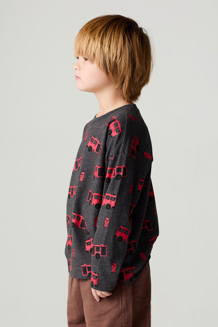 Side view of a boy wearing the Chaser Fire Trucks Boys Tee on a neutral background with arms at sides
