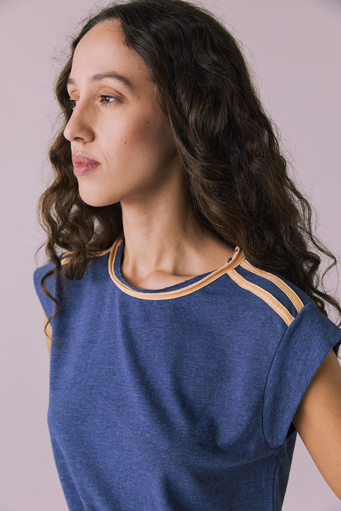 Close-up of the Chaser Flora Cropped Honest Indigo Cap Sleeve Crewneck Tee focusing on the tan striped trim at the neckline and shoulders
