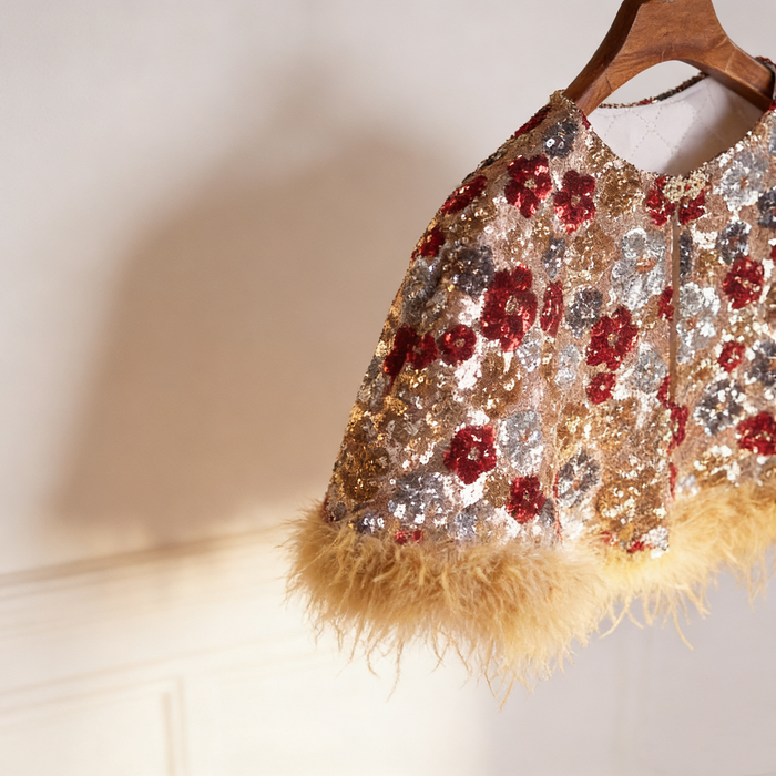Handcrafted floral sequin bridal capelet featuring shimmering embroidery with soft faux fur trim in gold and burgundy.