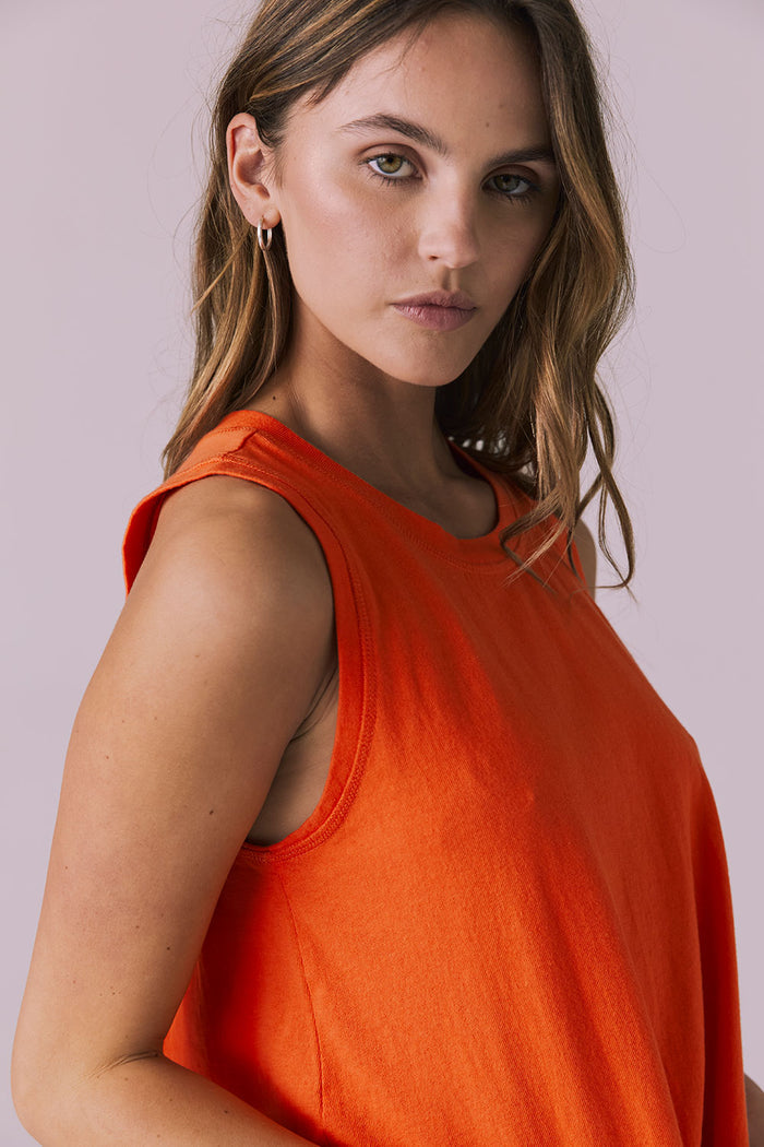 Close-up of the Chaser Flouncy Neon Flare Muscle Tank showing armhole detail and smooth neckline finish